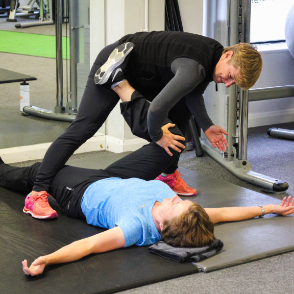 Helen Moseley stretching a client in the gym
